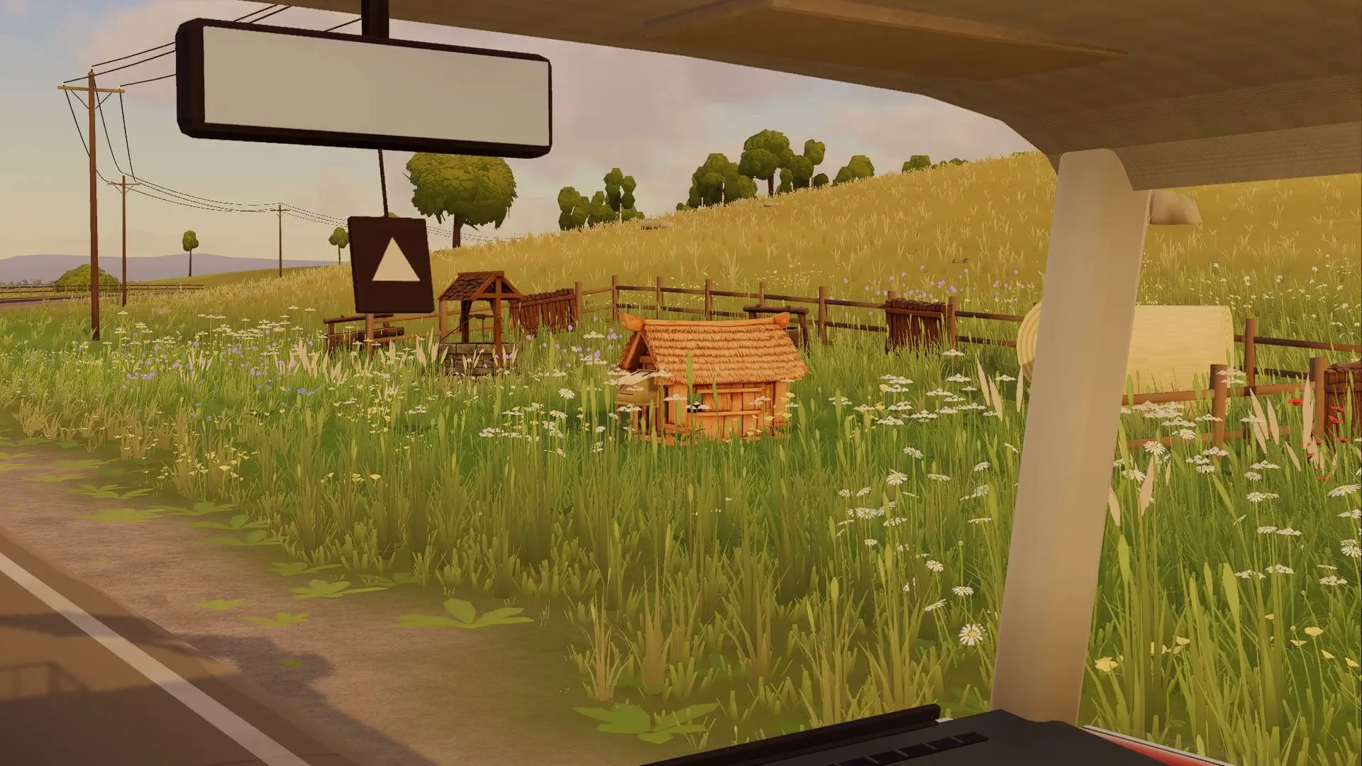 From the cab: a hen house and a fence in a meadow by the road